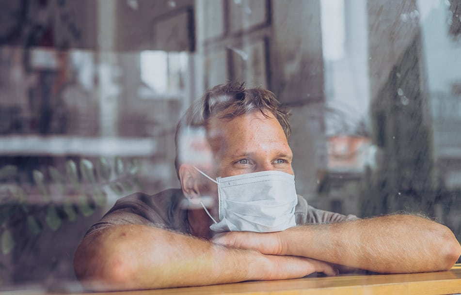 Man wearing mask in window